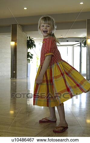 Stock Photo - Little girl in a yellow and red checked dress. Fotosearch