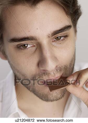 Man eating chocolate View Large Photo Image Stock Image - Man eating chocolate. Fotosearch