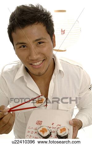 Man eating sushi with chopsticks View Large Photo Image Stock Photograph - Man eating sushi with chopsticks. Fotosearch