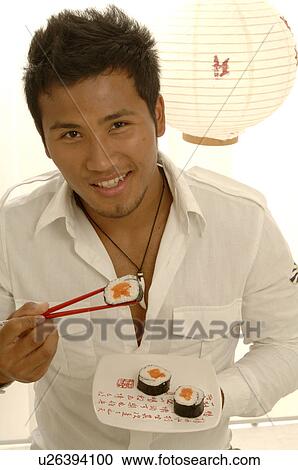 Man is eating sushi with chopsticks View Large Photo Image Stock Image - Man is eating sushi with chopsticks. Fotosearch