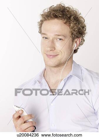 Stock Photograph - Man listening to mp3 player. Fotosearch