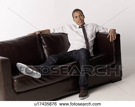Man relaxing on couch View Large Photo Image Stock Photograph - Man relaxing on couch. Fotosearch