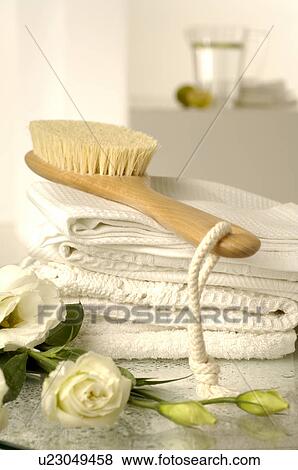 Stock Photo - piqué towels and a massage brush decorated with lisianthus flowers. Fotosearch