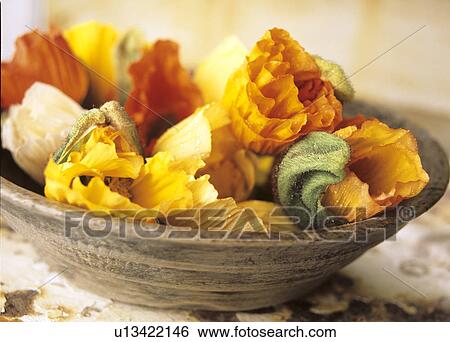 Stock Photograph - Poppy blossoms in a wooden bowl. Fotosearch
