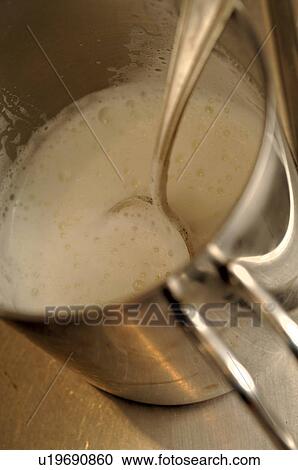 Stock Image - Pot filled with milk froth. Fotosearch