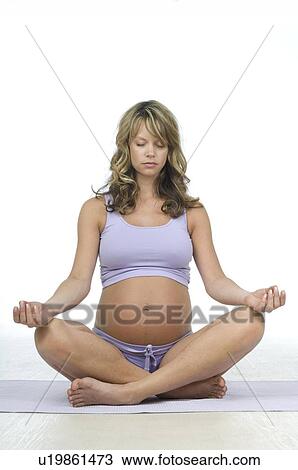 Stock Image - Pregnant woman in lotus position. Fotosearch