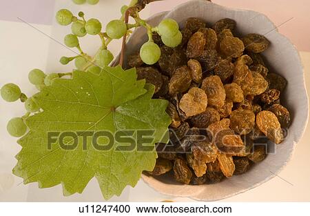 Stock Image - Raisins in a white bowl. Fotosearch