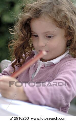 Stock Image - Readheaded child painting with lef hand. Fotosearch