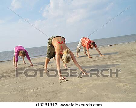 Stock Photo - Sportive excercises on the beach. Fotosearch