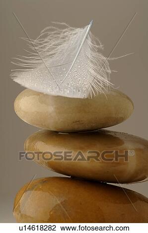 Stock Image - Stacked stones with a feather. Fotosearch
