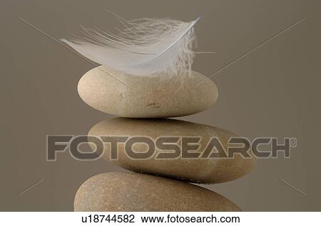 Stock Image - Stacked stones with a feather. Fotosearch
