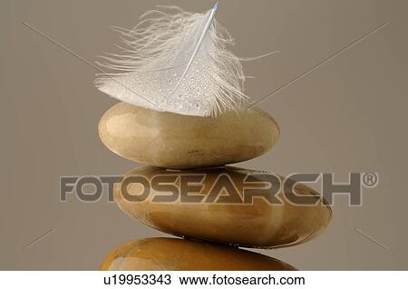 Stock Image - Stacked stones with a feather. Fotosearch