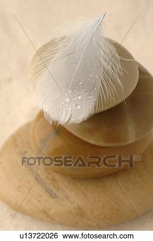 Stacked stones with a feather View Large Photo Image Stock Photograph - Stacked stones with a feather. Fotosearch