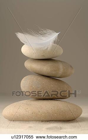 Stock Photography - Stacked stones with a feather. Fotosearch
