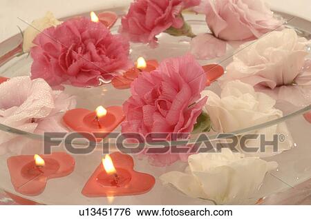 Stock Photograph - Swimming candles and blossoms in a bowl. Fotosearch