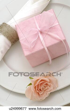 Stock Photo - Table decoration with pink rose and present. Fotosearch