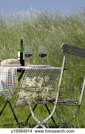 Picture - Table with red wine and bread outdoors. Fotosearch