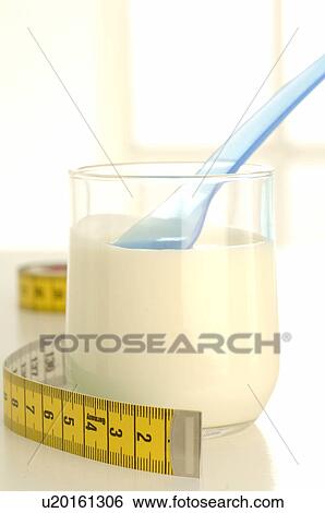 Stock Photograph - Tape measure and a glass with yoghurt. Fotosearch