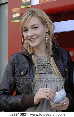 Stock Image - Teenage girl withdrawing money. Fotosearch