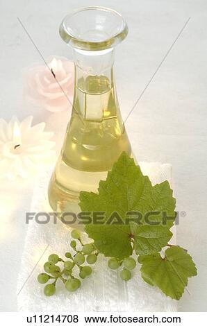 Stock Photo - Traubenkernöl aus weißen Trauben in einer Karaffe mit Kerzen. Fotosearch