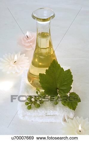 Stock Photo - Traubenkernöl aus weißen Trauben in einer Karaffe mit Kerzen. Fotosearch