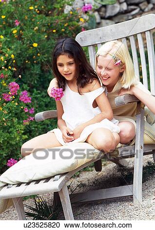 two girls on a deck chair View Large Photo Image Stock Image - two girls on a deck chair. Fotosearch