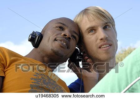 Two men listening to music View Large Photo Image Stock Photography - Two men listening to music. Fotosearch