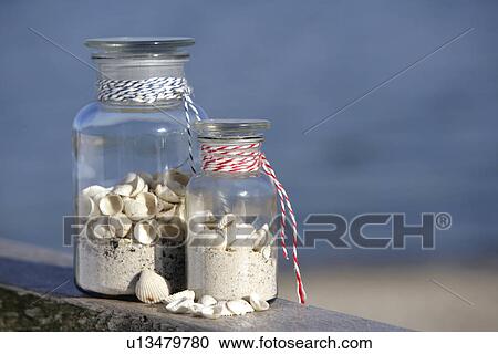 Stock Image - Two pharmacy bottles filled with sand and shells. Fotosearch