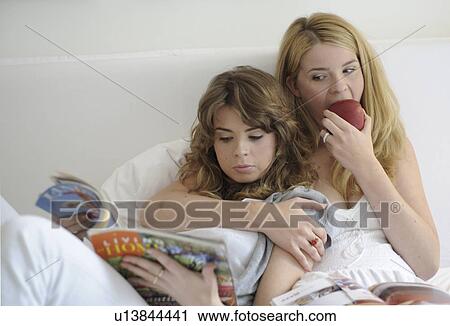 Stock Image - Two young women readig the newspaper. Fotosearch