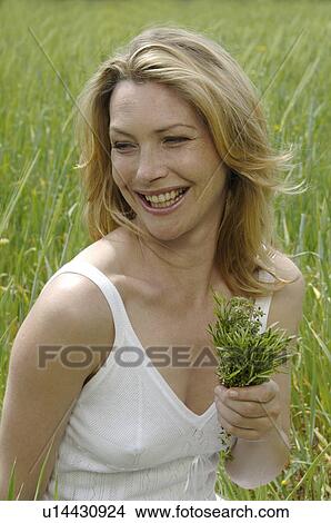White dressed women with a bunch of weeds is sitting in a meadow View Large Photo Image Picture - White dressed women with a bunch of weeds is sitting in a meadow. Fotosearch