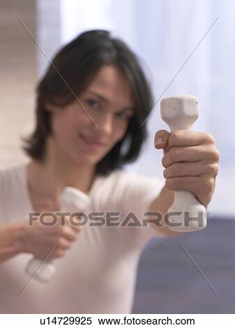 Woman doing exercises with dumbbells View Large Photo Image Stock Photography - Woman doing exercises with dumbbells. Fotosearch