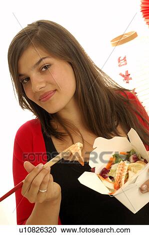Woman eating asian dish with chopsticks View Large Photo Image Stock Image - Woman eating asian dish with chopsticks. Fotosearch