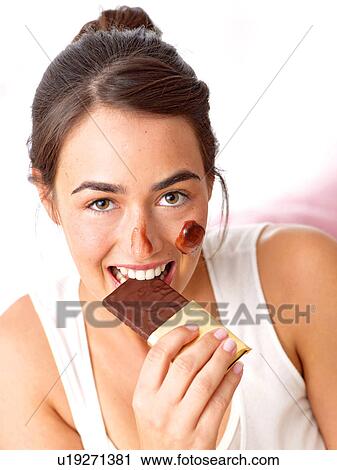Stock Image - Woman eating chocolate. Fotosearch