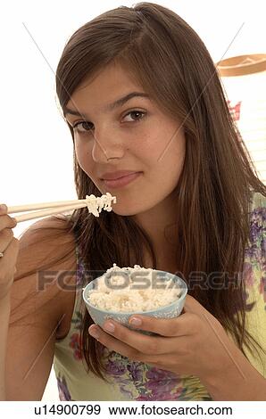 Stock Photo - Woman eating rice with chopsticks. Fotosearch