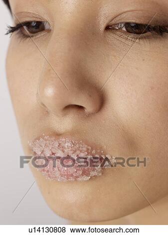 Stock Photo - Woman having salt exfoliation on her mouth. Fotosearch