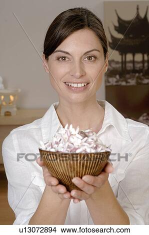 Woman holding a bowl filled with blossoms View Large Photo Image Picture - Woman holding a bowl filled with blossoms. Fotosearch