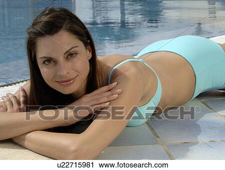 Woman in a turquoise bikini is lying at the swimming pool View Large Photo Image Stock Image - Woman in a turquoise bikini is lying at the swimming pool. Fotosearch