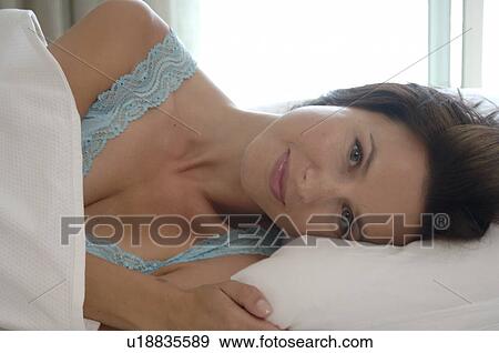 Stock Photo - Woman in bed with pillow. Fotosearch