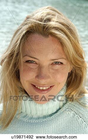 Stock Image - Woman in turquoise pullover at the sea. Fotosearch