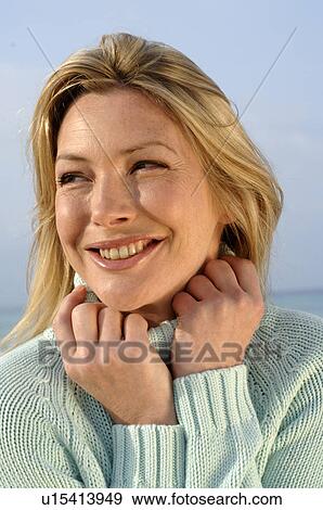 Stock Photo - Woman in turquoise pullover at the sea. Fotosearch