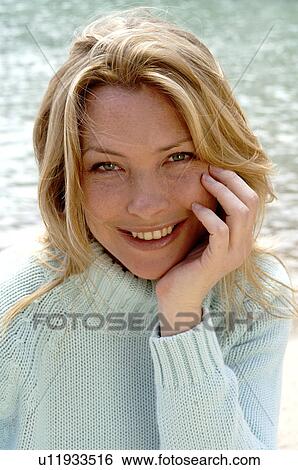 Stock Photograph - Woman in turquoise pullover at the sea. Fotosearch
