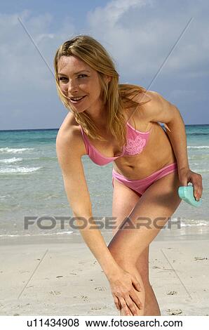 Woman is applying sunlotion View Large Photo Image Stock Photo - Woman is applying sunlotion. Fotosearch