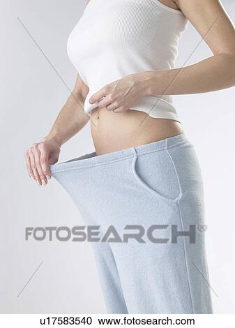 Woman is checking her weight View Large Photo Image Stock Image - Woman is checking her weight. Fotosearch
