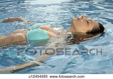 Stock Image - Woman is doing backstroke. Fotosearch
