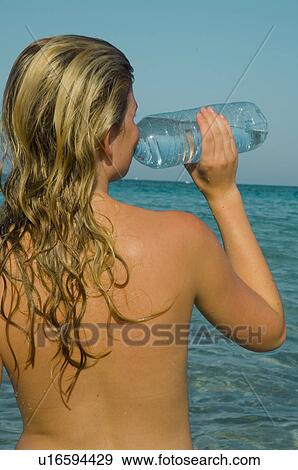 Woman is drinking water from a bottle View Large Photo Image Stock Photo - Woman is drinking water from a bottle. Fotosearch