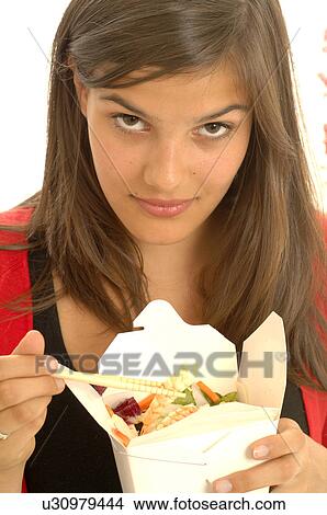 Woman is eating Asian food with chopsticks View Large Photo Image Picture - Woman is eating Asian food with chopsticks. Fotosearch