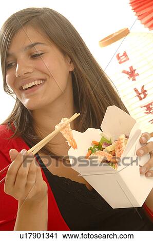 Woman is eating Asian food with chopsticks View Large Photo Image Stock Image - Woman is eating Asian food with chopsticks. Fotosearch