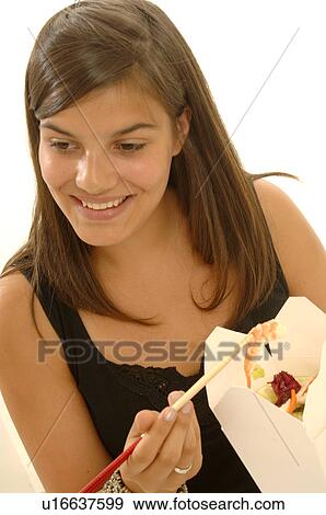 Woman is eating Asian food with chopsticks View Large Photo Image Stock Photo - Woman is eating Asian food with chopsticks. Fotosearch