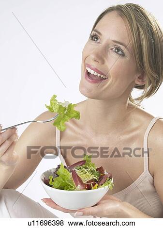 Woman is eating salad View Large Photo Image Stock Photo - Woman is eating salad. Fotosearch