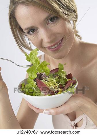 Woman is eating salad View Large Photo Image Stock Photo - Woman is eating salad. Fotosearch